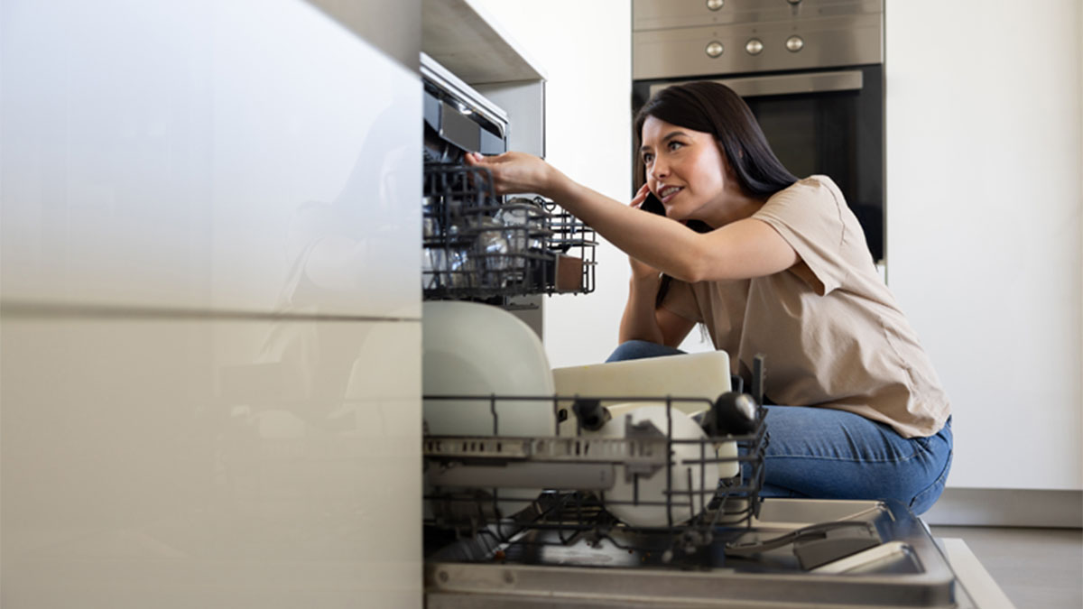 jovem adulta a fazer a manutenção da máquina da loiça 